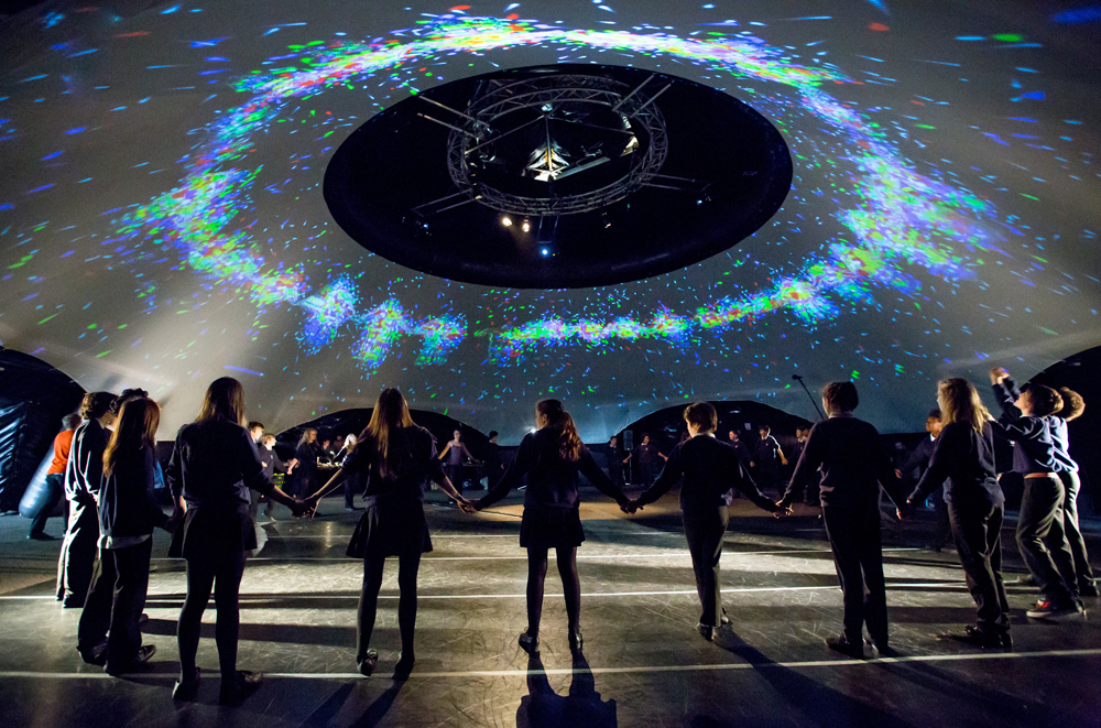 A dancer and a person lying on the floor one is wearing a VR headset